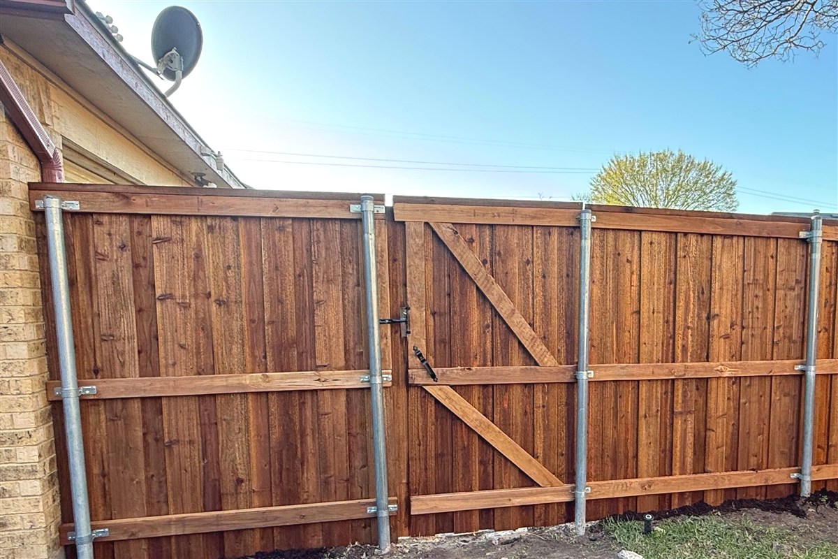 Wood privacy fence with walk-through gate in backyard